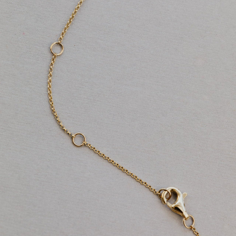 Gold chain necklace with clasp on a gray background
