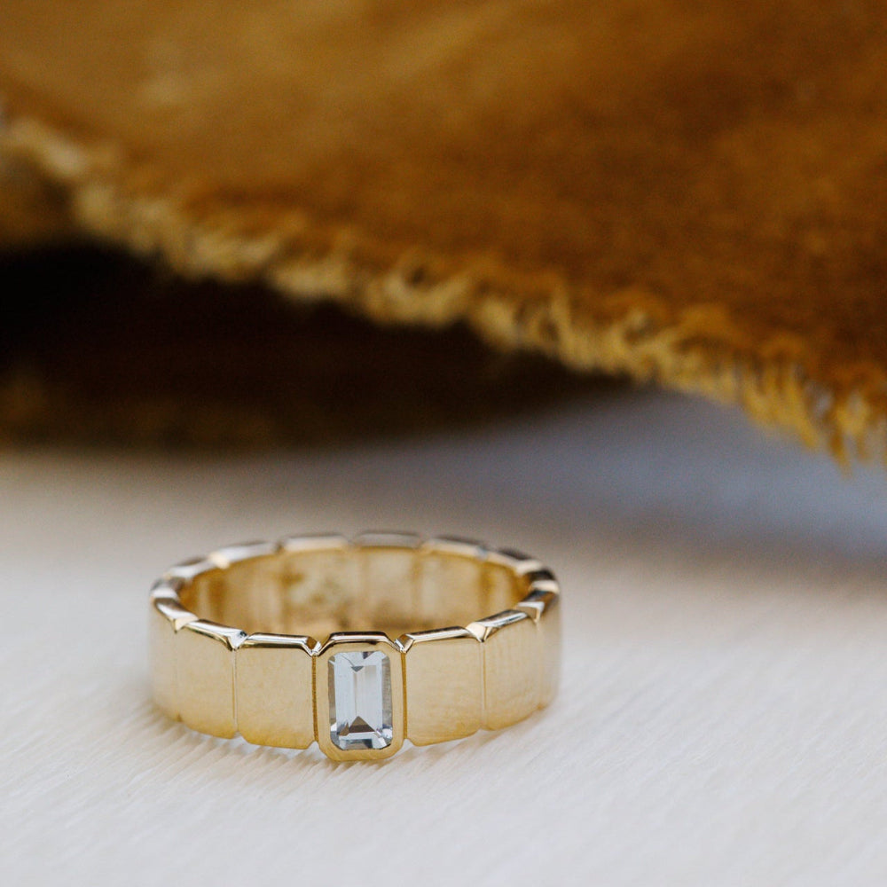 Gold ring with a diamond on a textured surface
