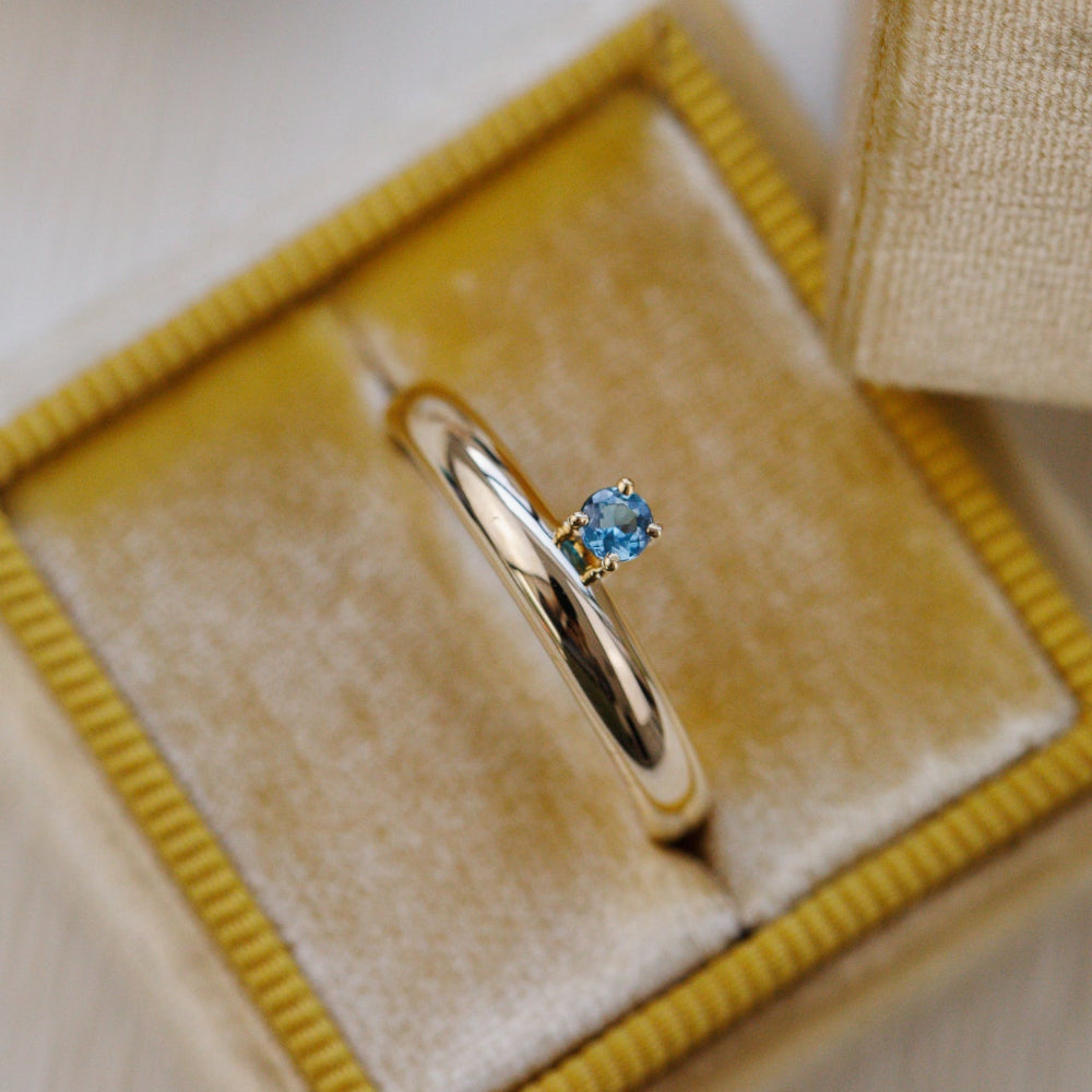 Gold ring with a blue gemstone in a jewelry box
