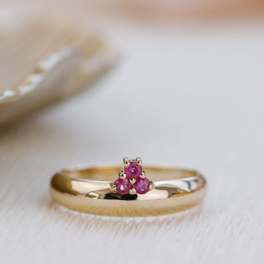 Gold ring with ruby gemstones on a soft background