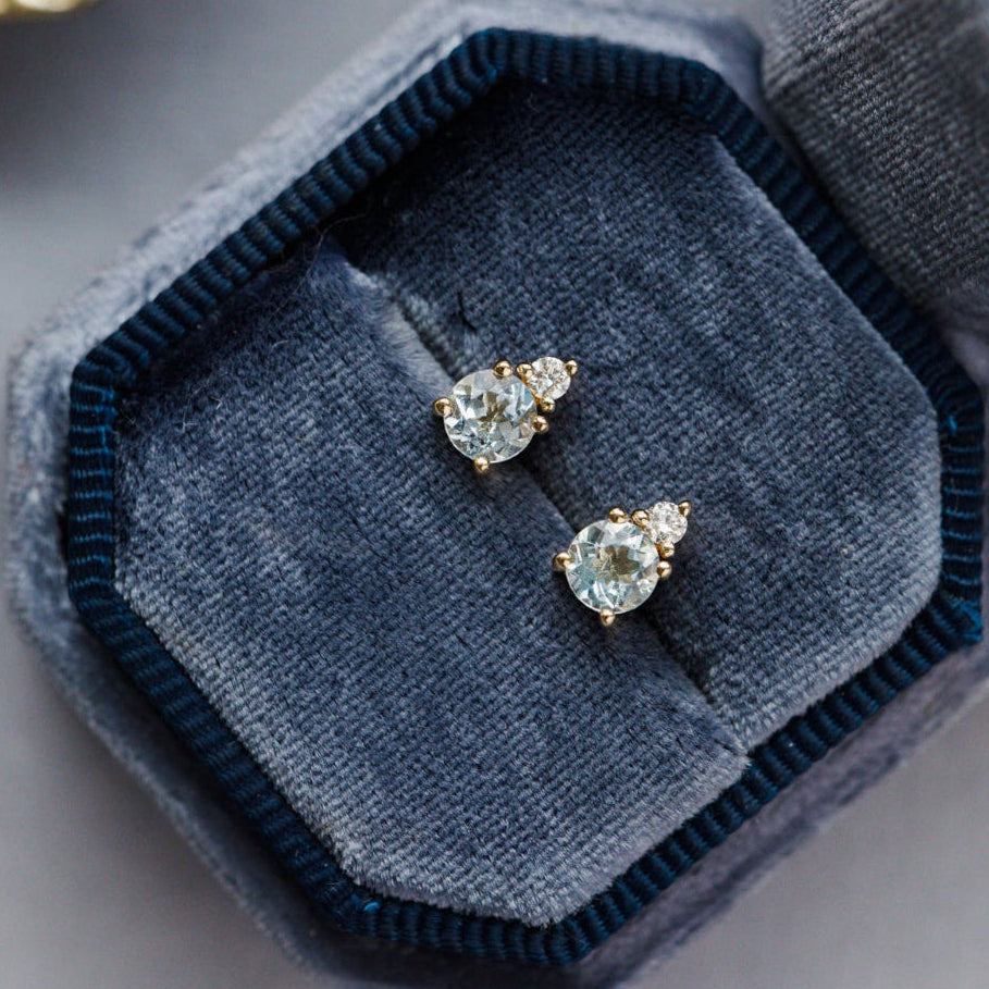 Pair of heart-shaped gemstone earrings in a blue velvet box.
