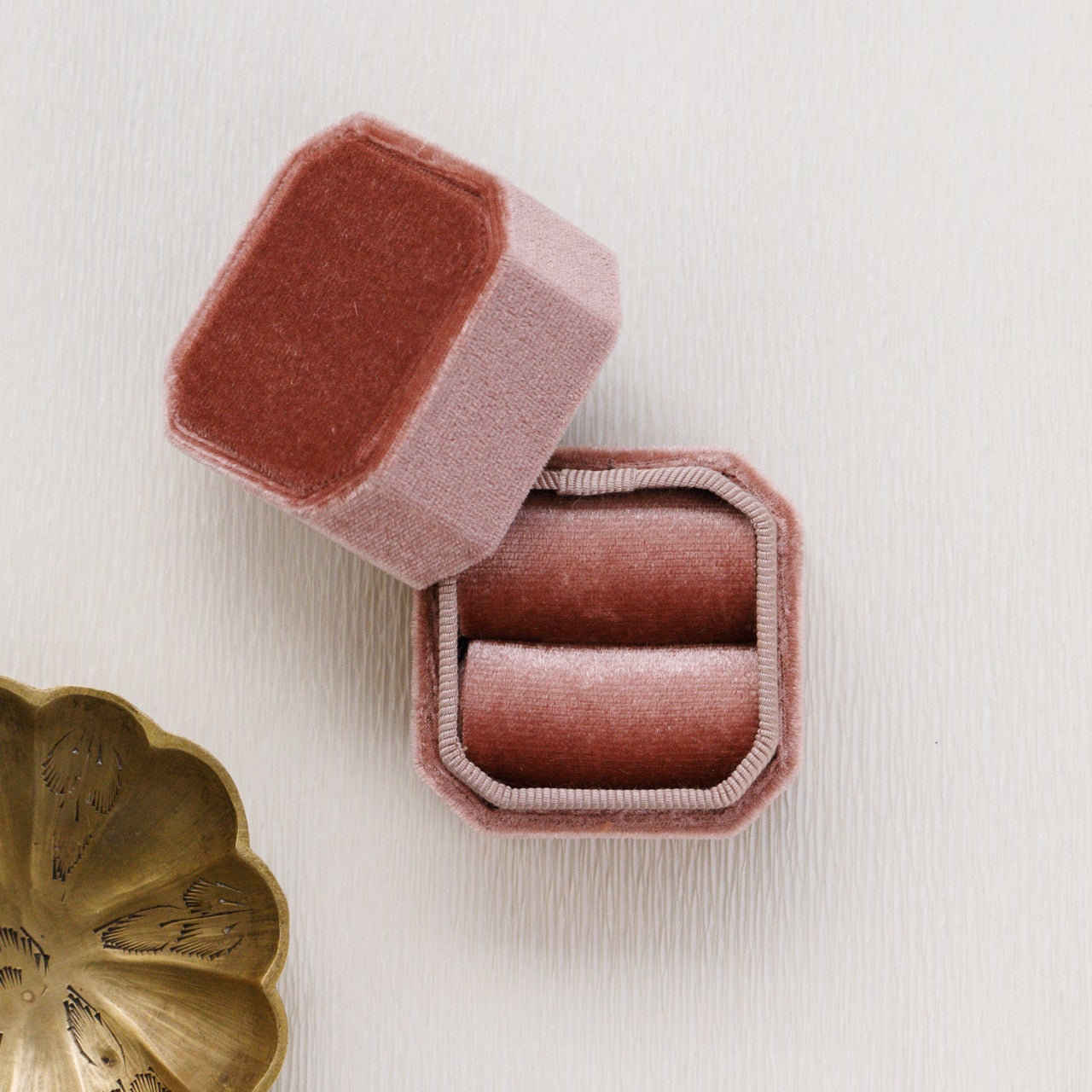 Pink velvet jewelry box with a gold dish on a light background