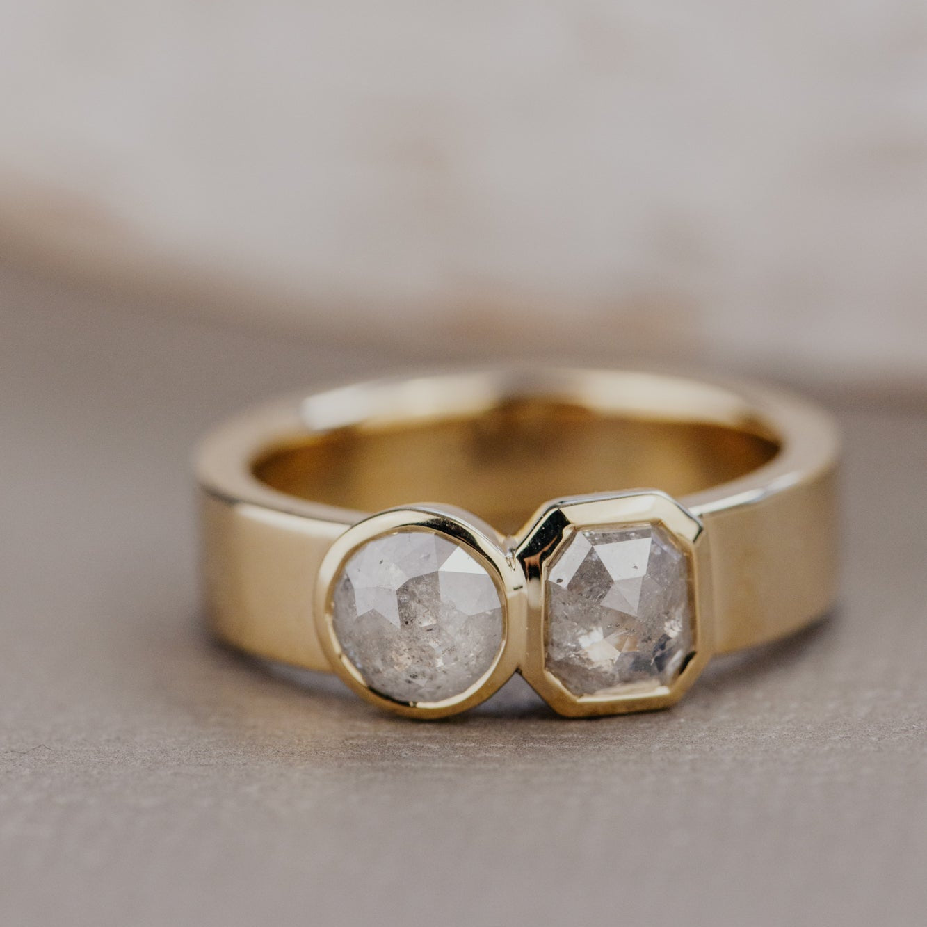 Gold Madison ring with two rustic diamonds on a neutral background.