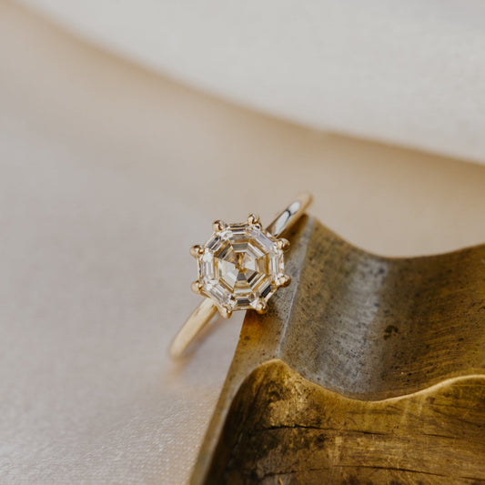 Gold ring with a octagon champagne diamond on a textured surface.