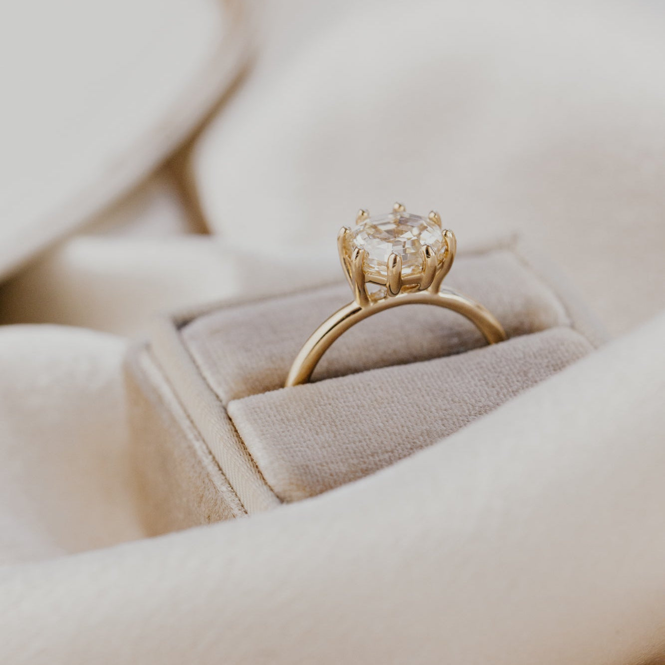 Gold ring with a champagne diamond in a jewelry box.