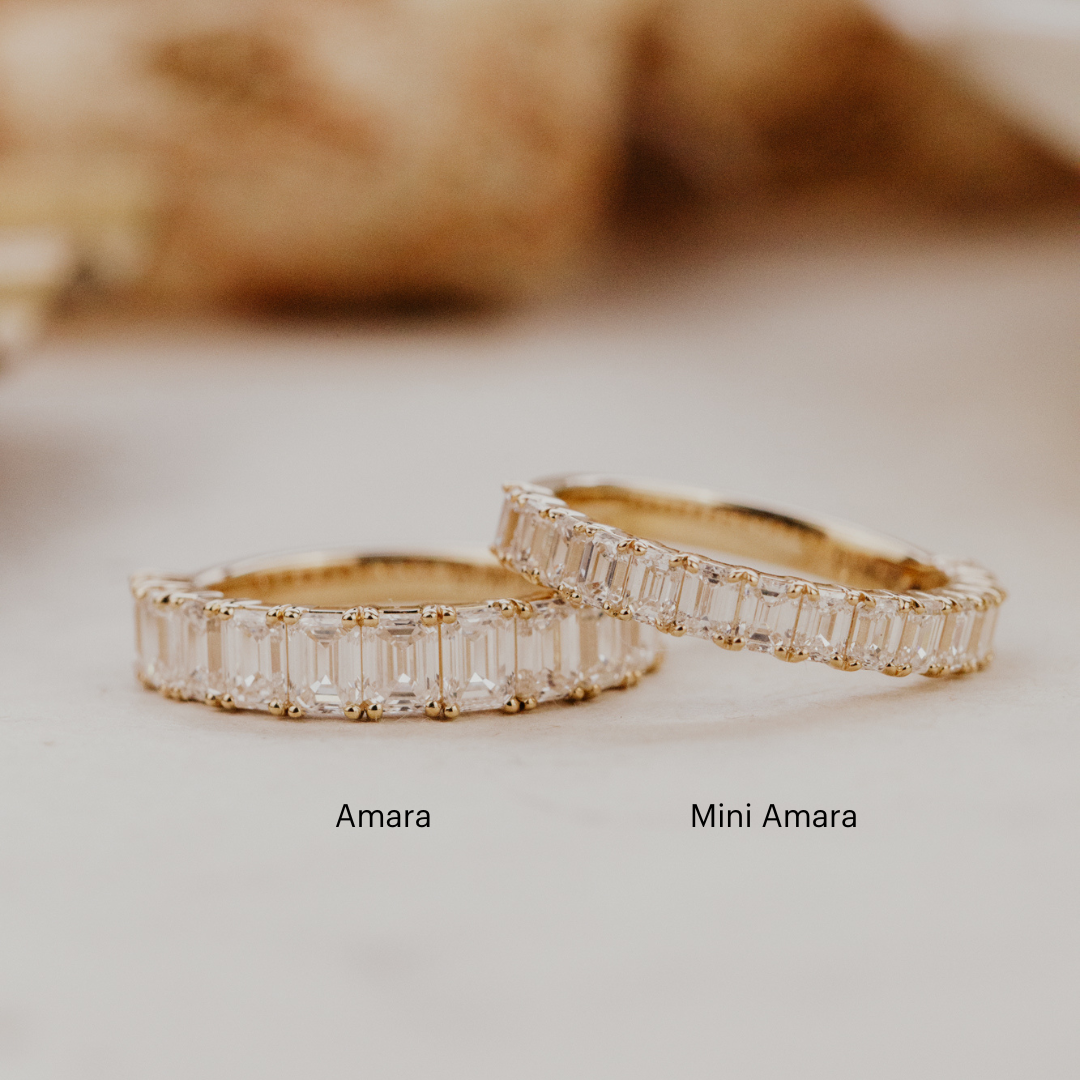The Amara and the mini Amara emerald cut diamond bands with labels on a white surface.