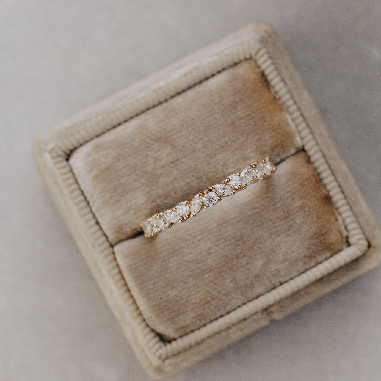 The Natalie diamond wedding band in a beige jewelry box on a neutral background.