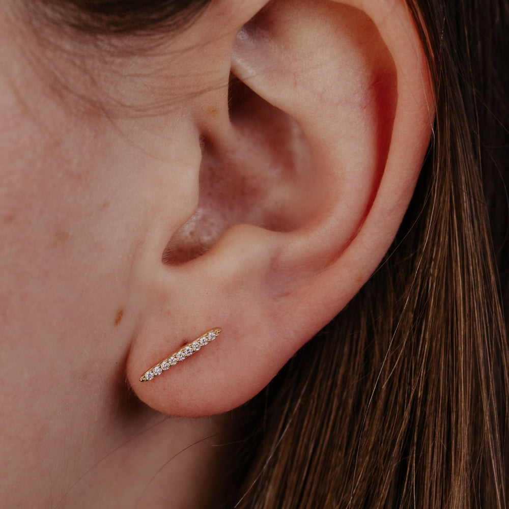 Close-up of an ear with a diamond earrings.