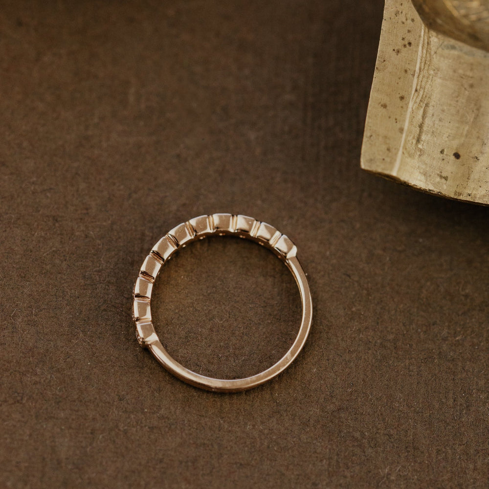 Gold ring on a brown surface with a book in the background