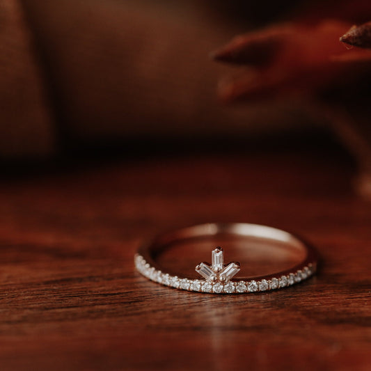 Diamond wedding band on a wooden surface with a blurred background.