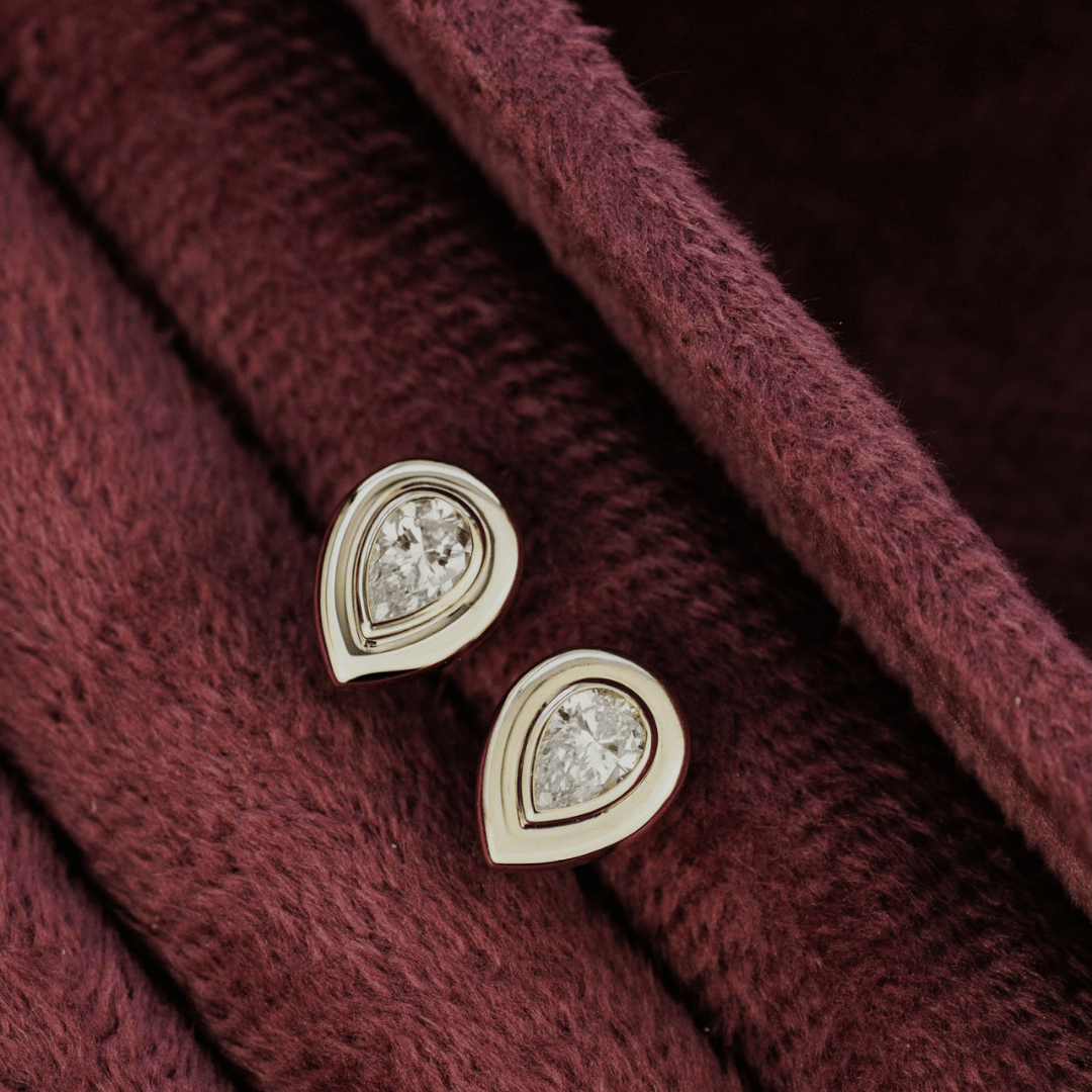 14k gold lab grown diamond earrings showcased in a red earring box. 