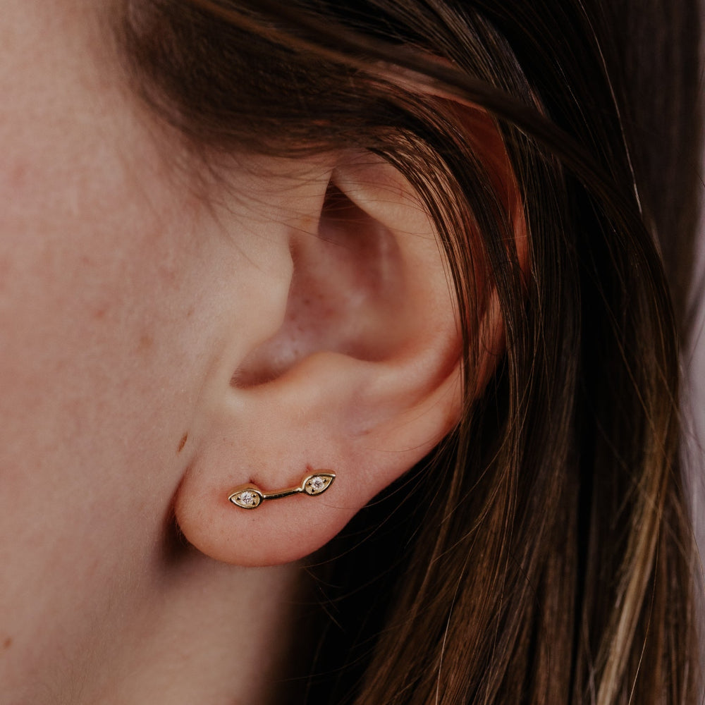 Close-up of an ear with a gold diamond earring.