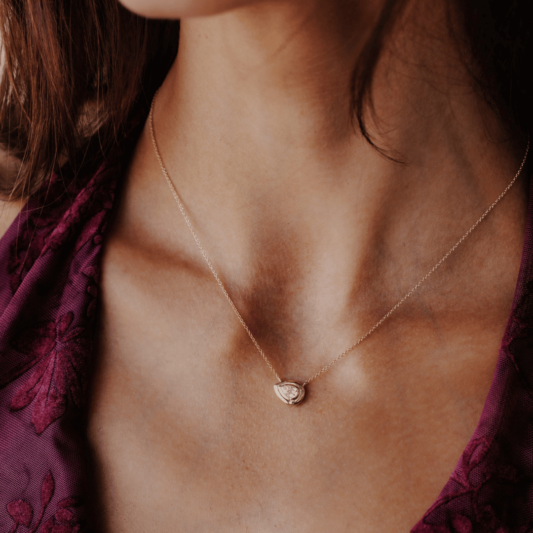 14k gold pear cut, lab grown diamond chain necklace showcased on the neck of a model.