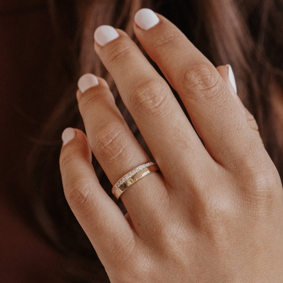 Close-up of a hand with a ring on a blurred background