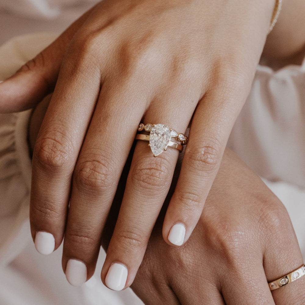 Close-up of a hand wearing a diamond ring with a blurred background