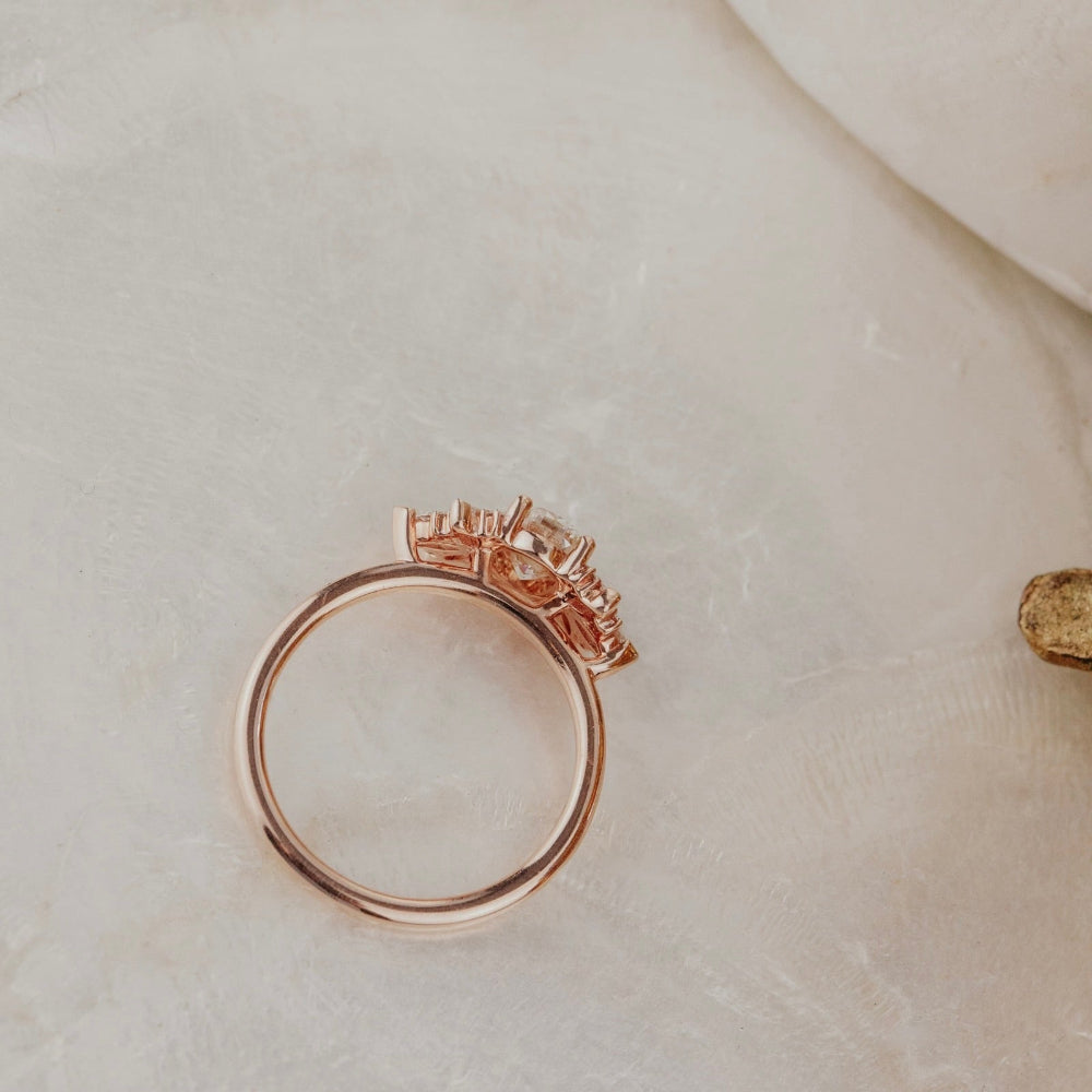 Rose gold ring with a champagne diamond on a light beige surface.