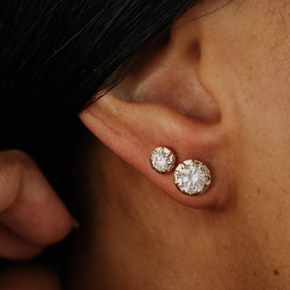 Close-up of a person wearing lab grown diamond stud earrings.