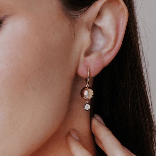 14k gold round cut, lab grown diamond dangle/hoop earrings with Black Rhodium featured on the ear of a model. 