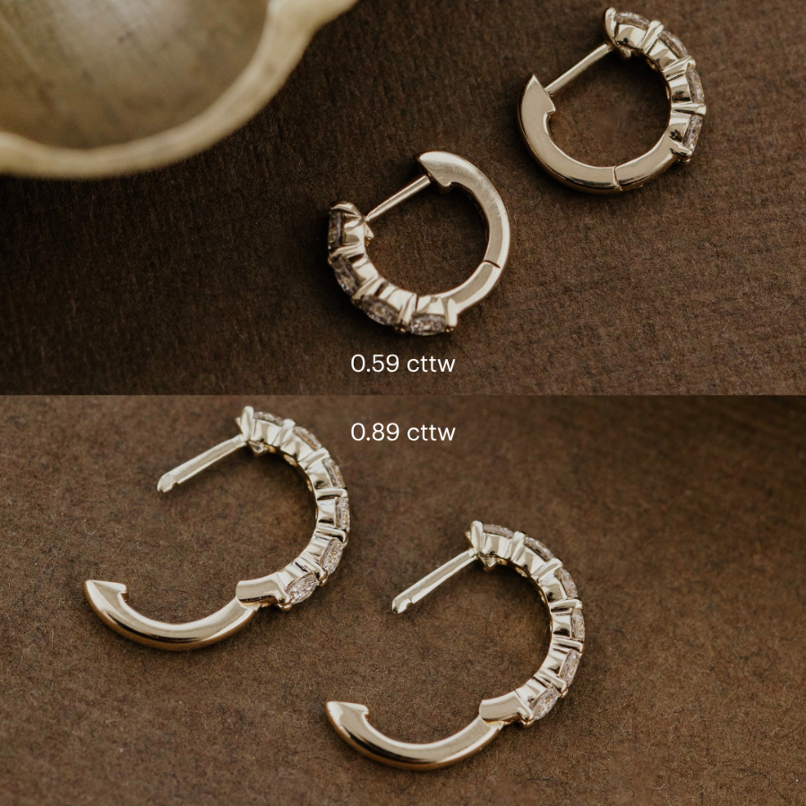 gold hoop earrings with lab grown diamons on a brown surface.
