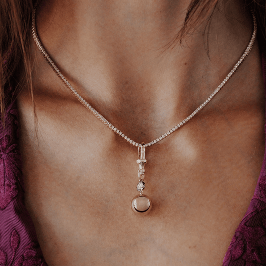 A Round cut Lab Grown Diamond with a Black Rhodium Round Ball Dog Clip Pendant Necklace shown on the neck of a model. 