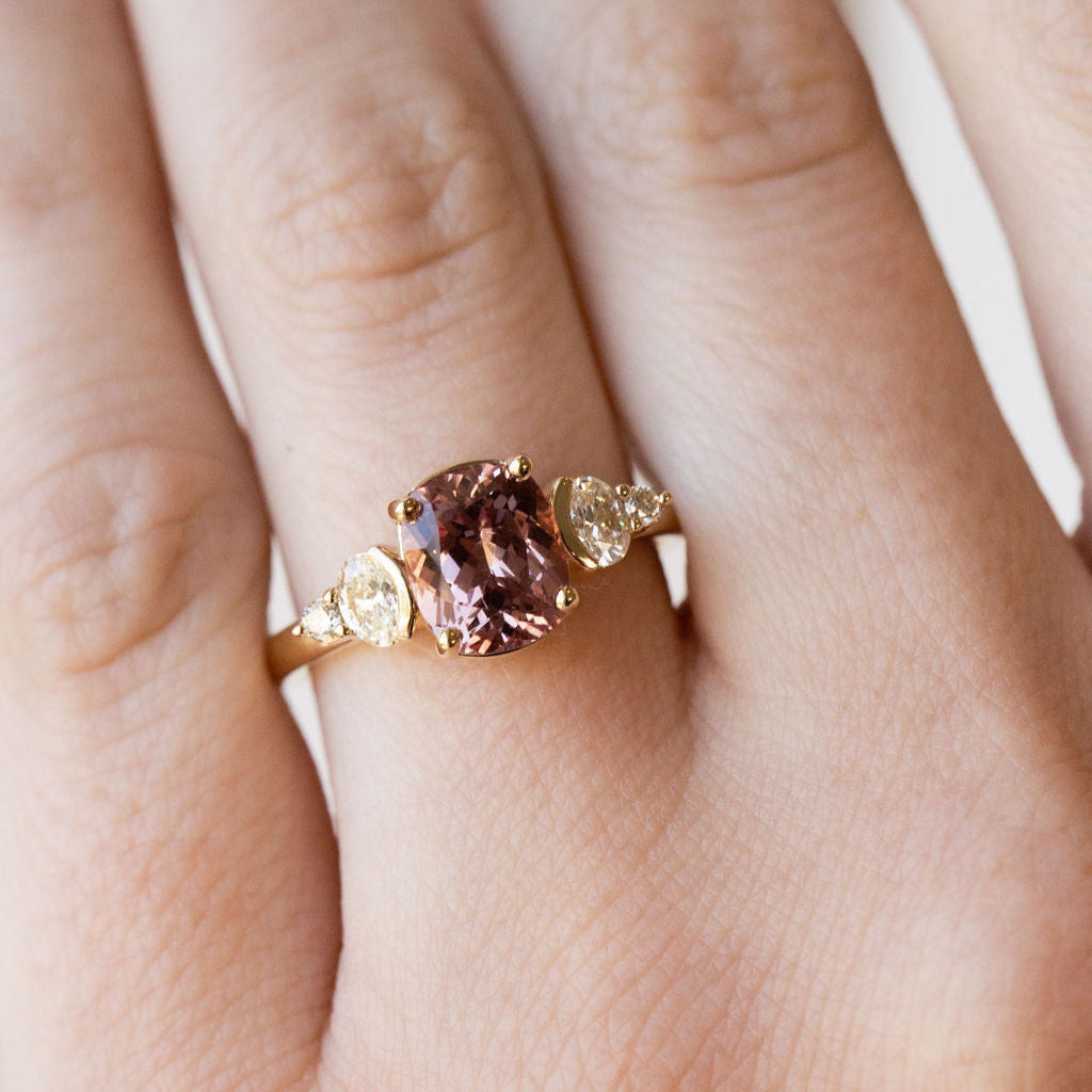 Gold ring with a pink garnet gemstone on a hand