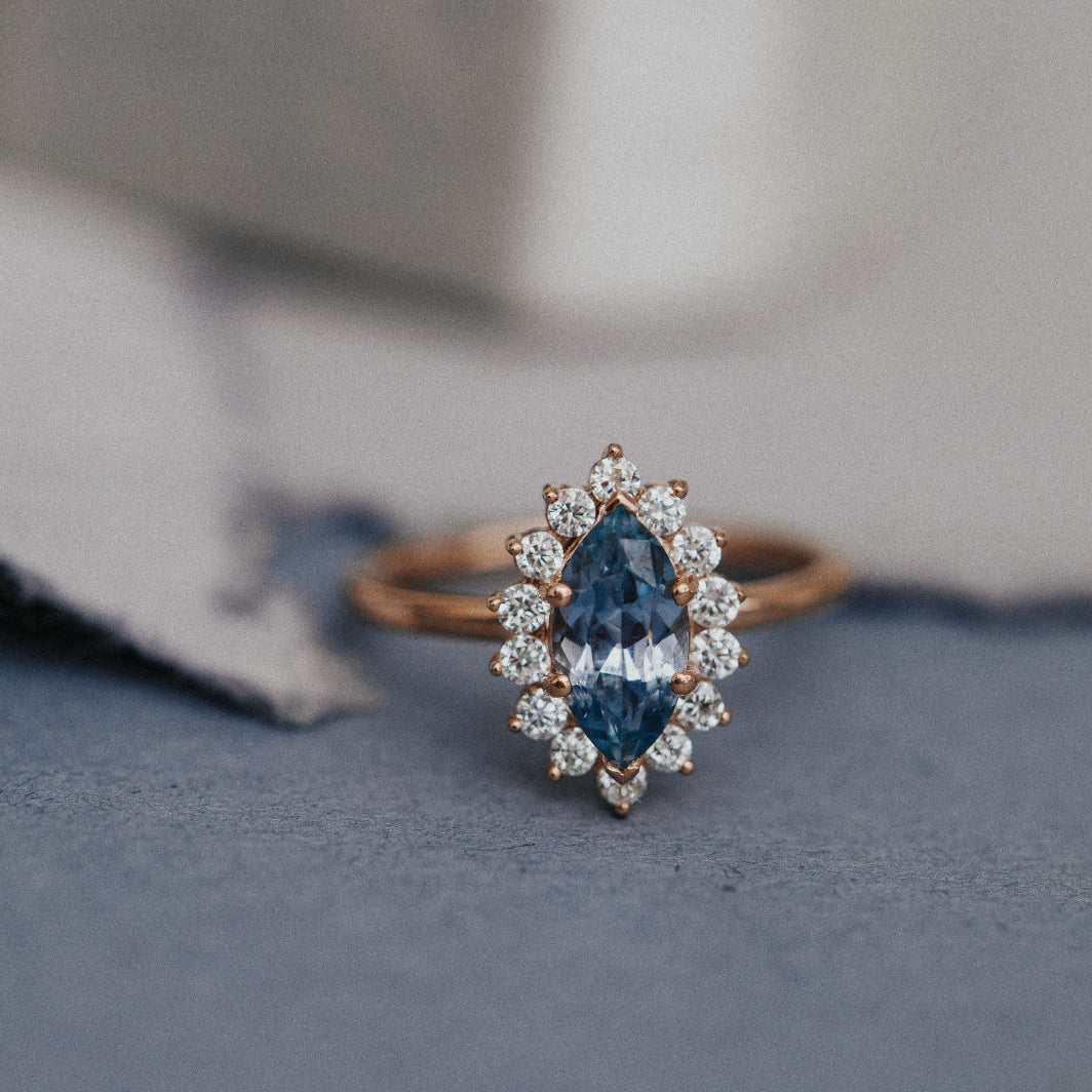 Diamond ring with blue sapphire gemstone on a textured surface