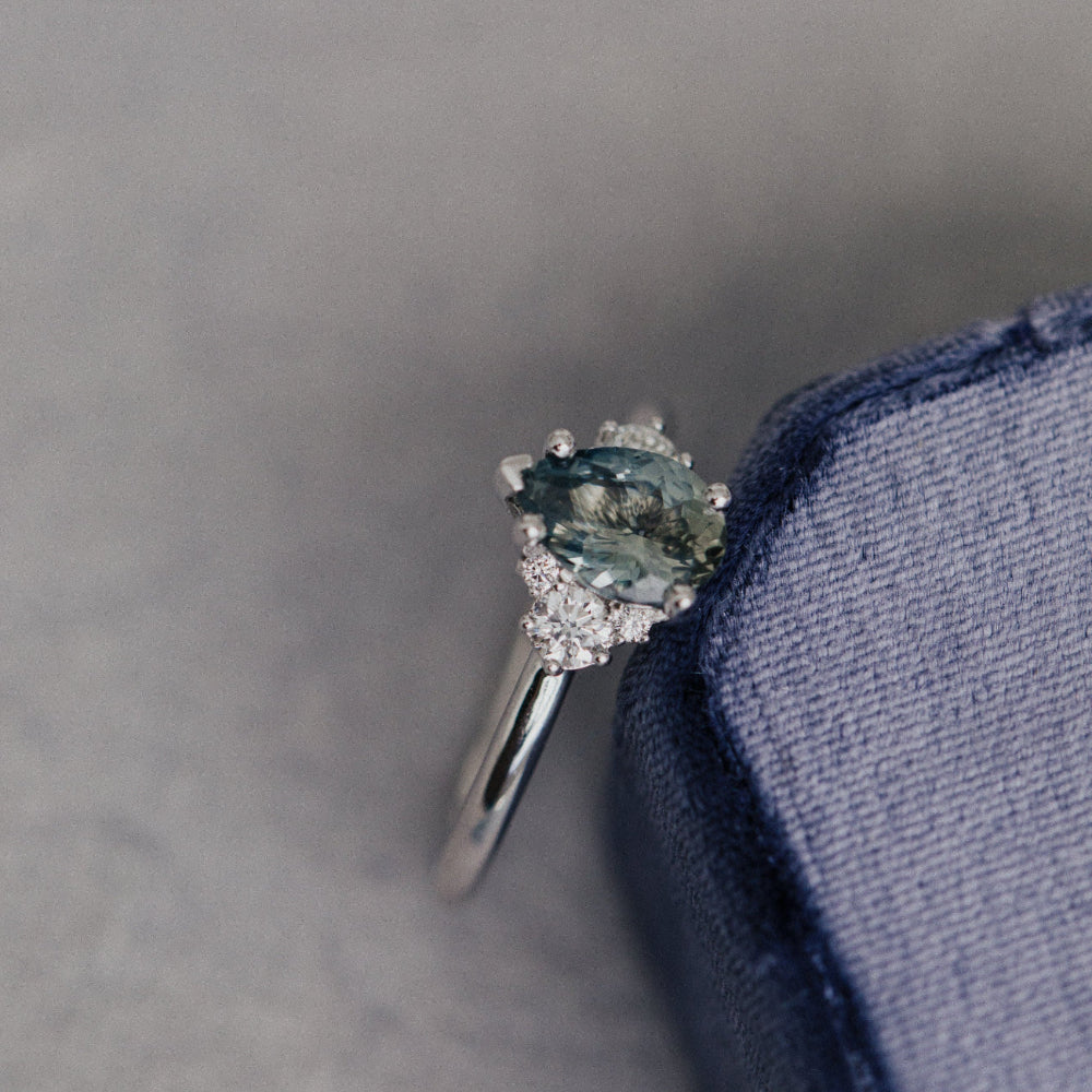 Ring with a blue sapphire gemstone on a gray background