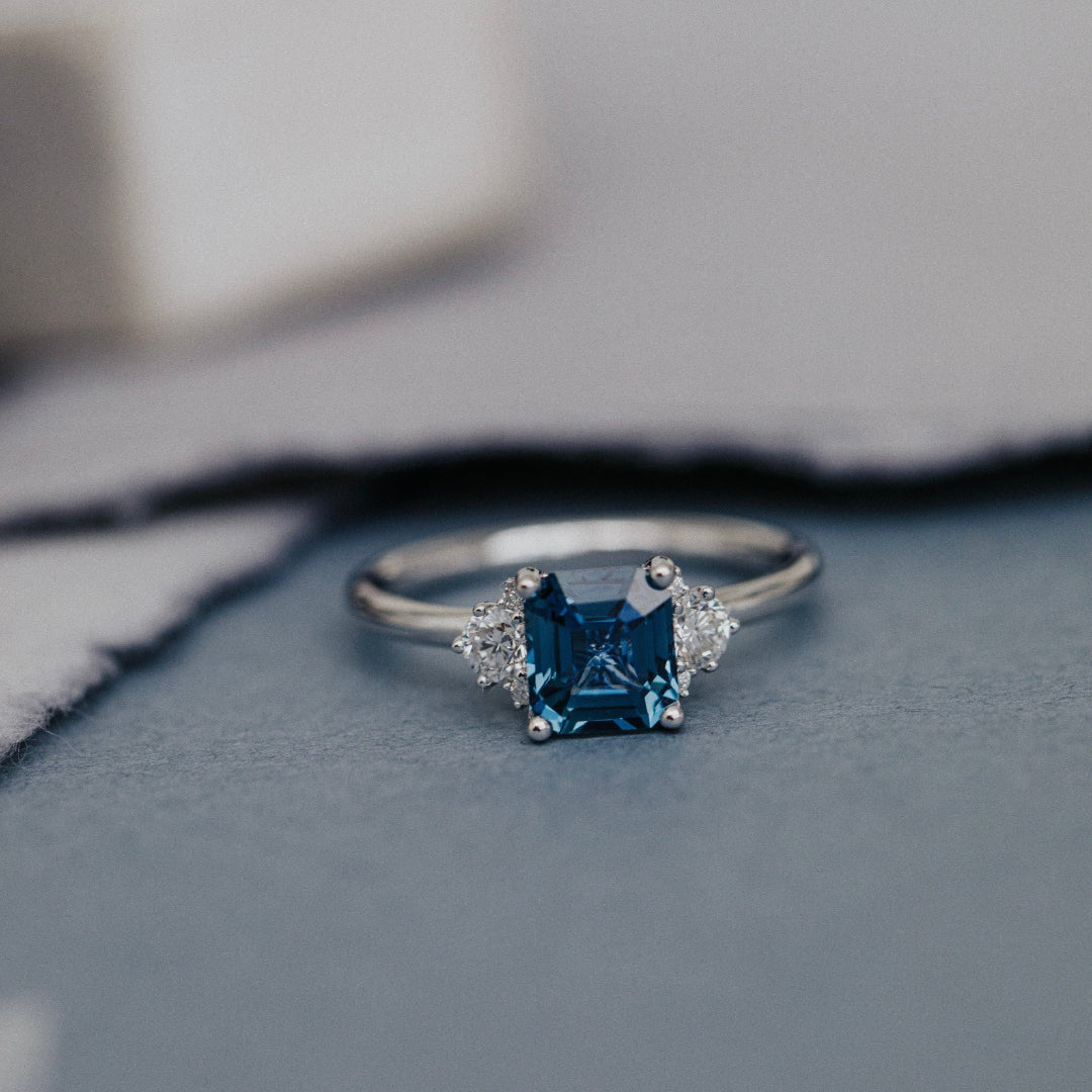 Silver ring with a blue Montana Sapphire on a textured surface