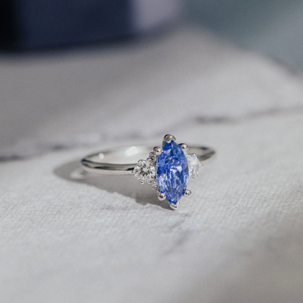 Ring with a blue sapphire on a soft fabric background