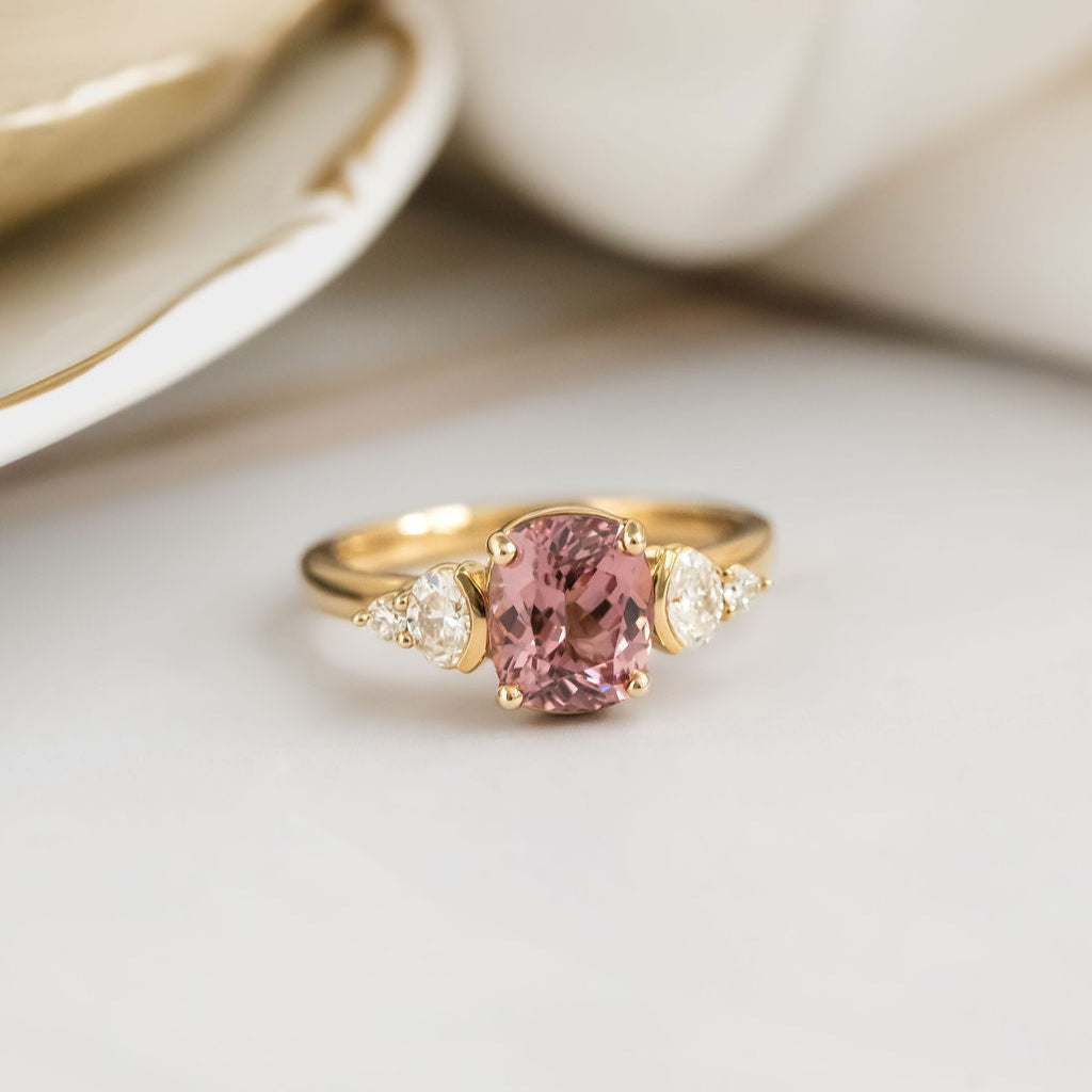 Gold ring with a pink garnet on a light background