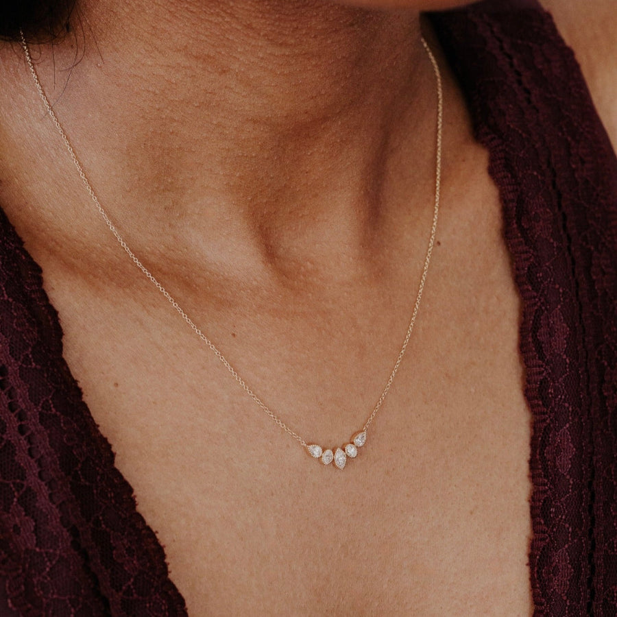Gold necklace with small diamond stones on a person's neck