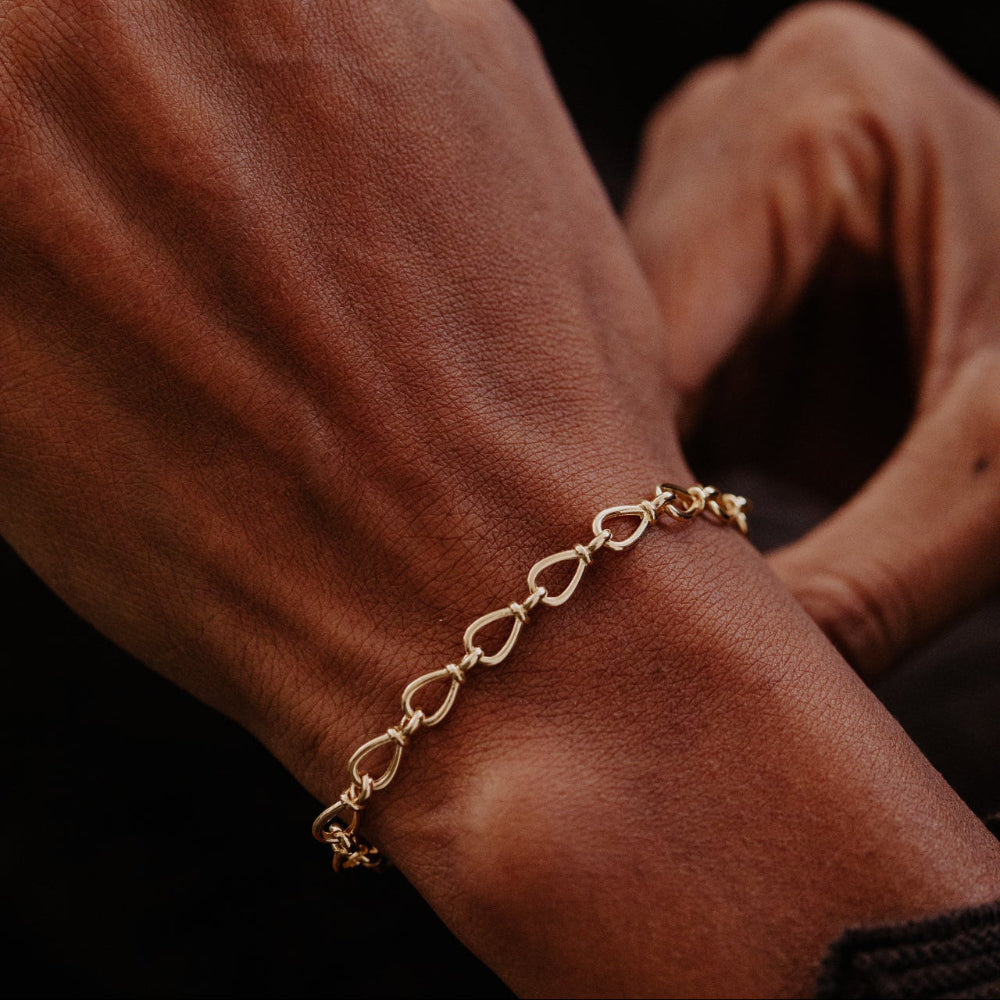 Gold bracelet on a wrist with a blurred background