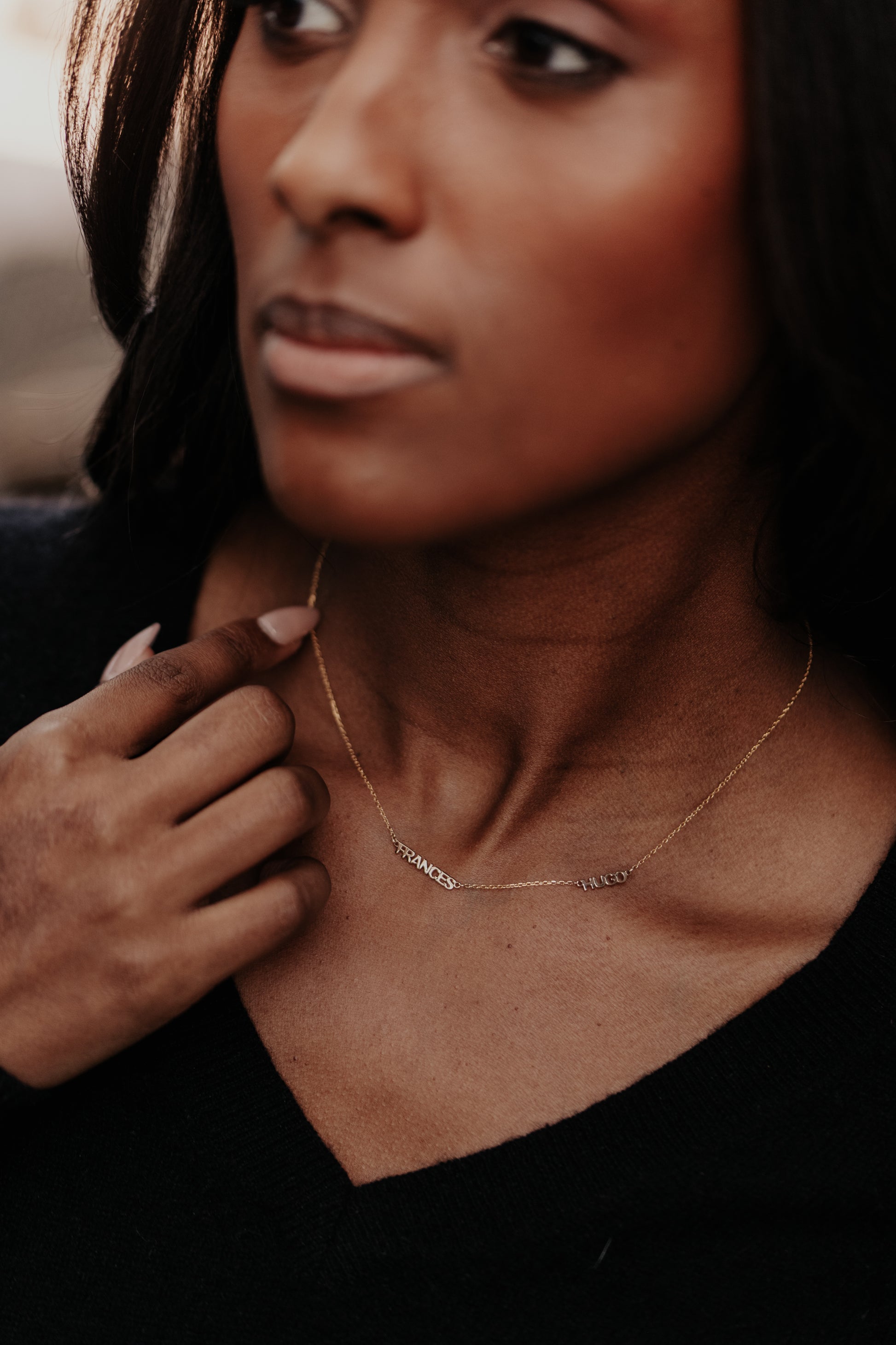 Personalized name necklace with 2 custom names set on a 14k gold chain and styled on a models neck