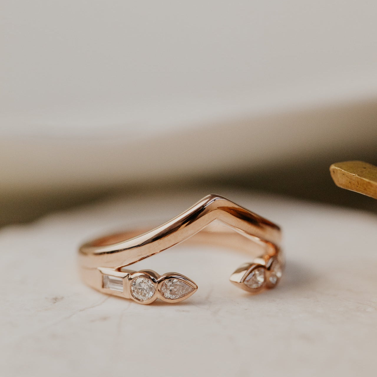 Rose gold wedding bands with diamond accents on a light background