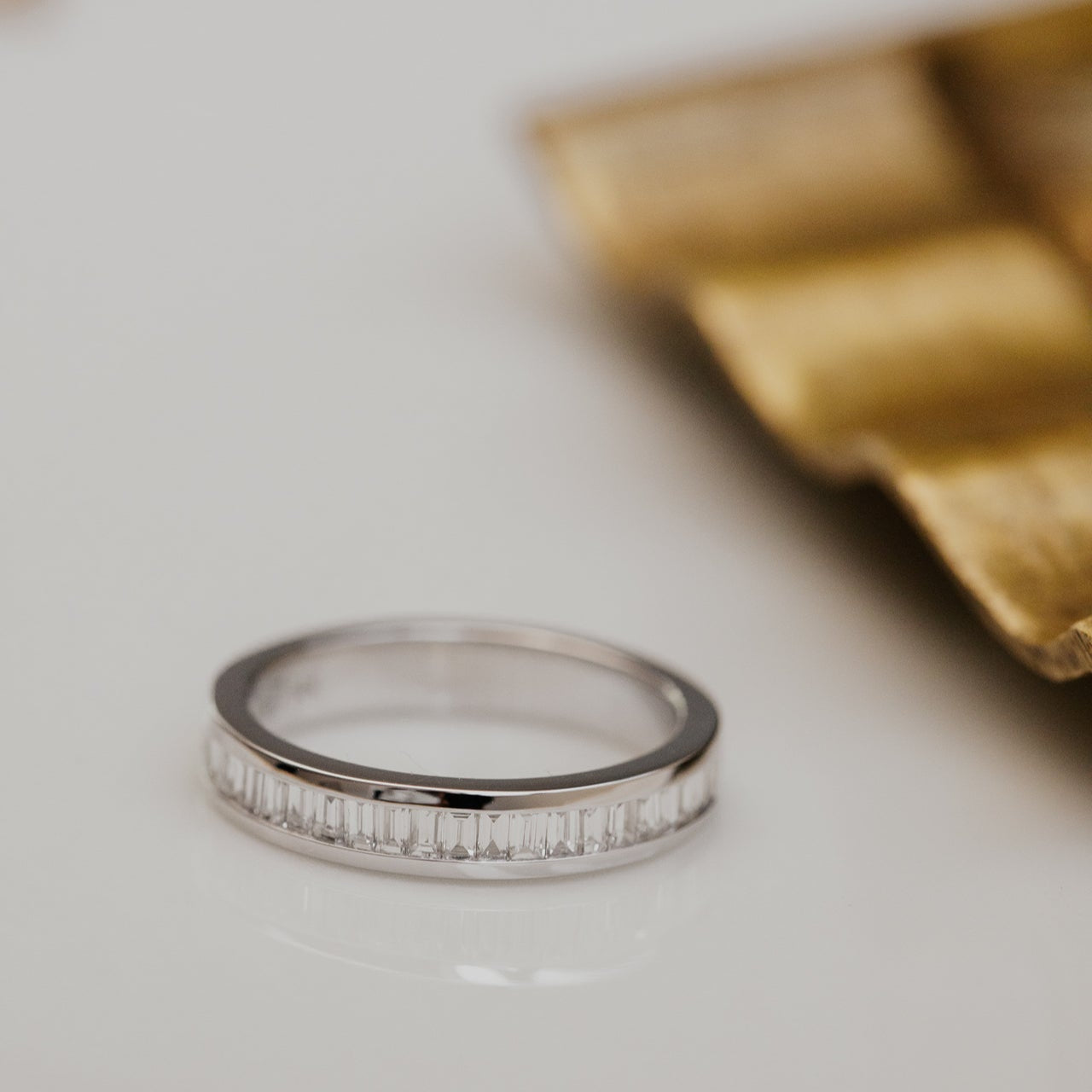 white gold wedding band with diamond accents on a light background