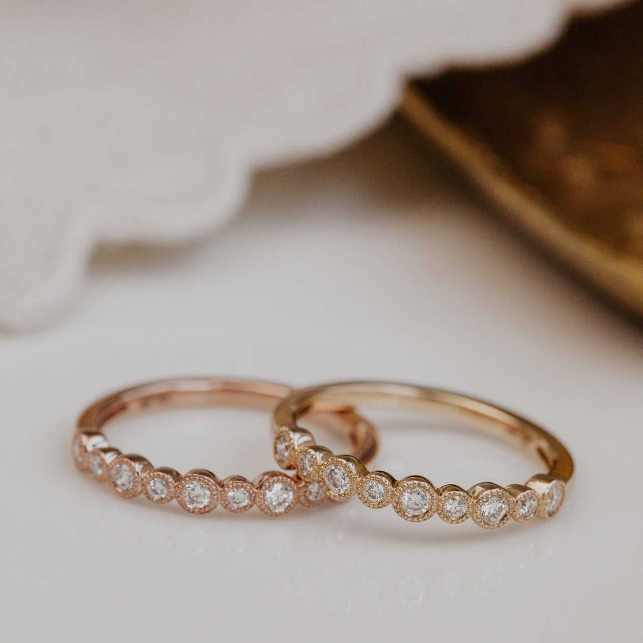 Two gold wedding bands with round diamond on a soft surface