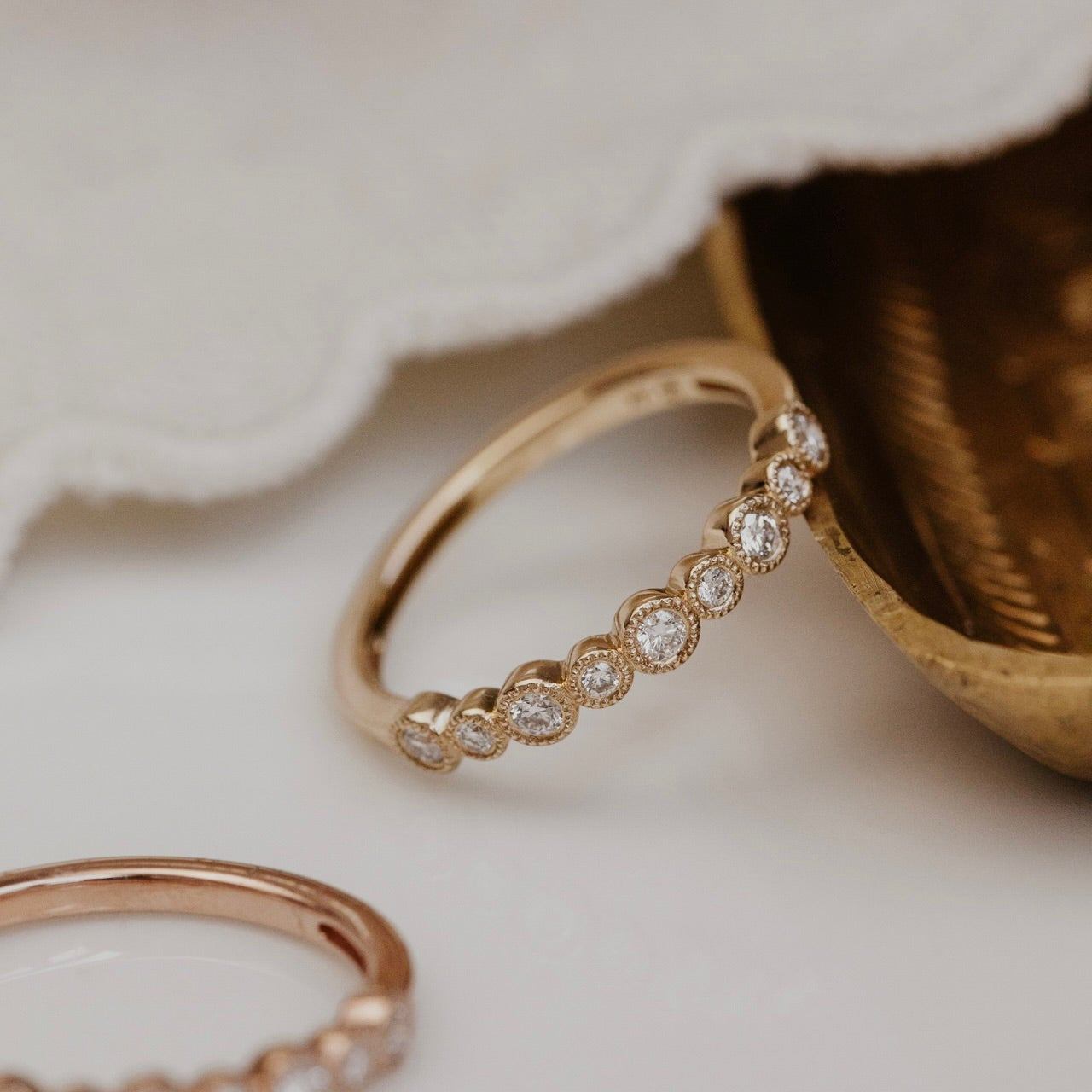 Gold wedding band with diamond accents on a soft background