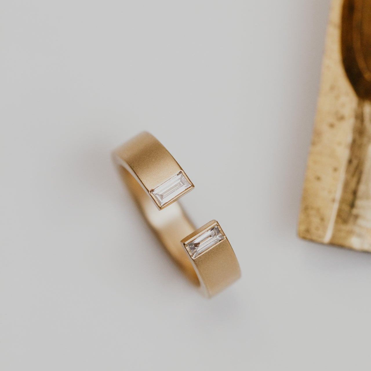 Gold band with diamond accents on a light gray background