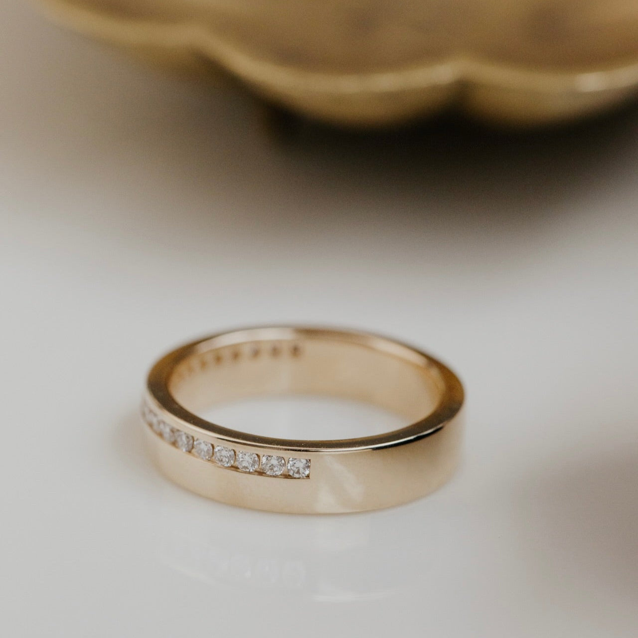 Gold wedding bands with small diamonds on a light background