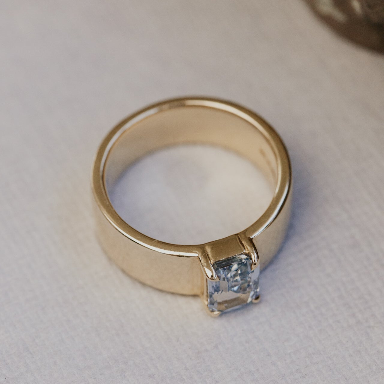 Gold ring with a blue sapphire on a white background