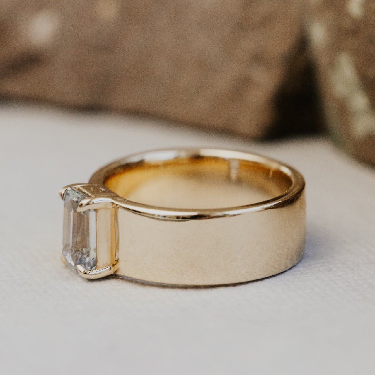 Gold ring with a blue sapphire on a light background