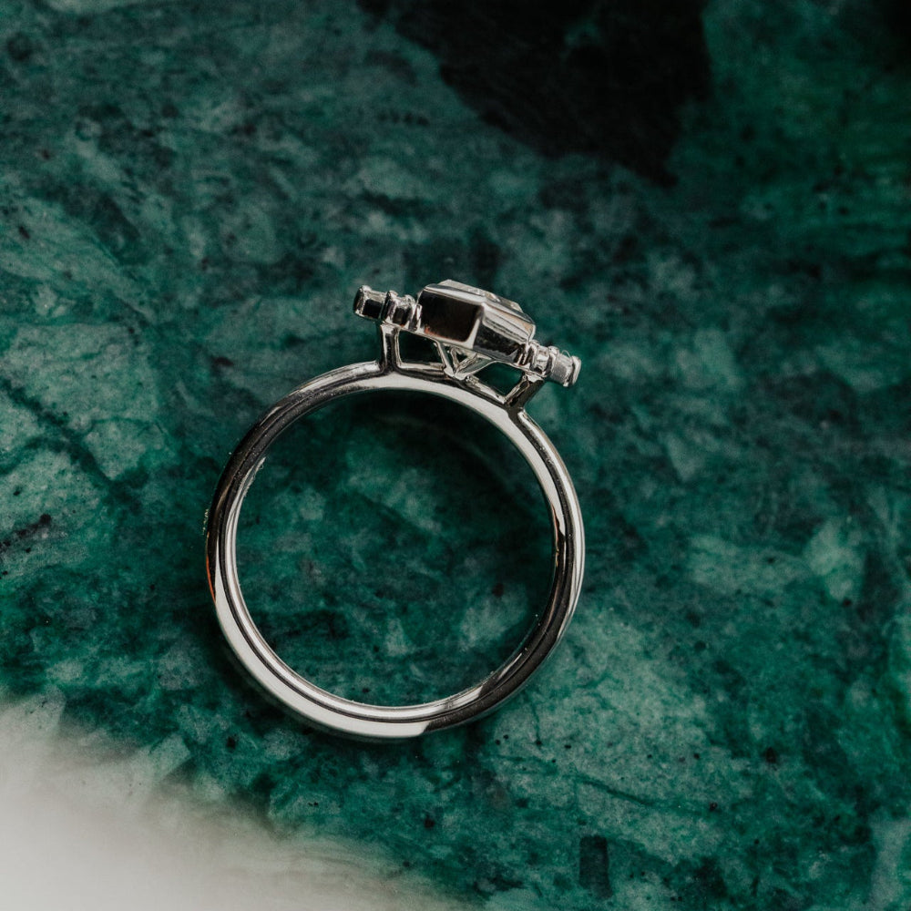 White gold diamond ring on a green textured surface