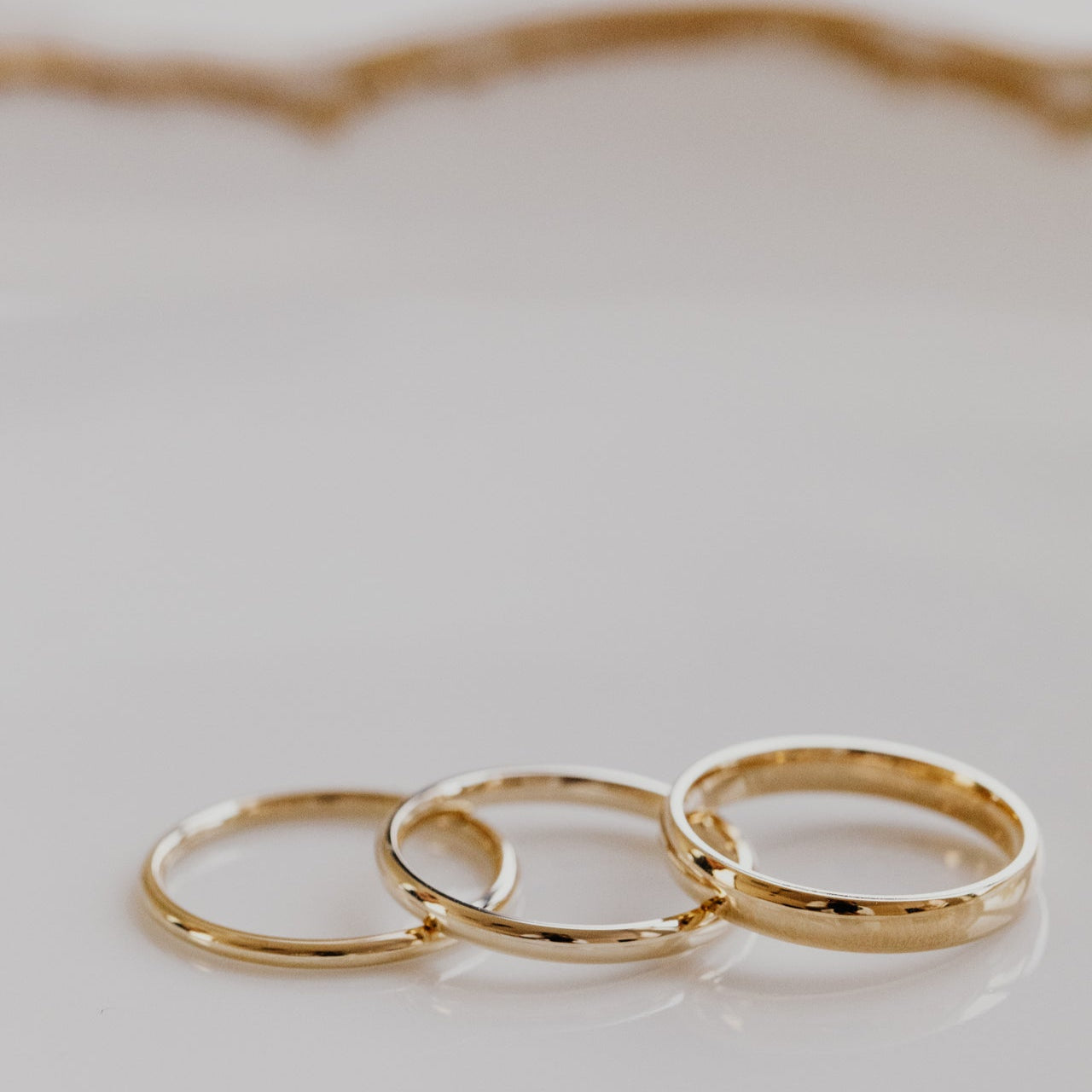 Three gold rings on a light gray background