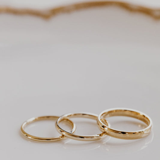 Three gold rings on a light gray background