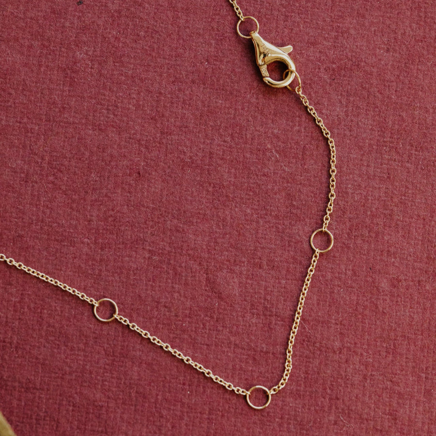 Gold chain necklace on a red fabric background
