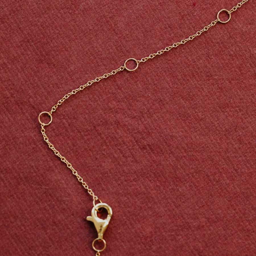 Gold chain bracelet on a red background