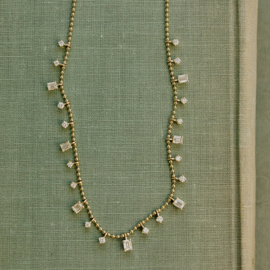 Necklace with square diamonds on a green fabric background