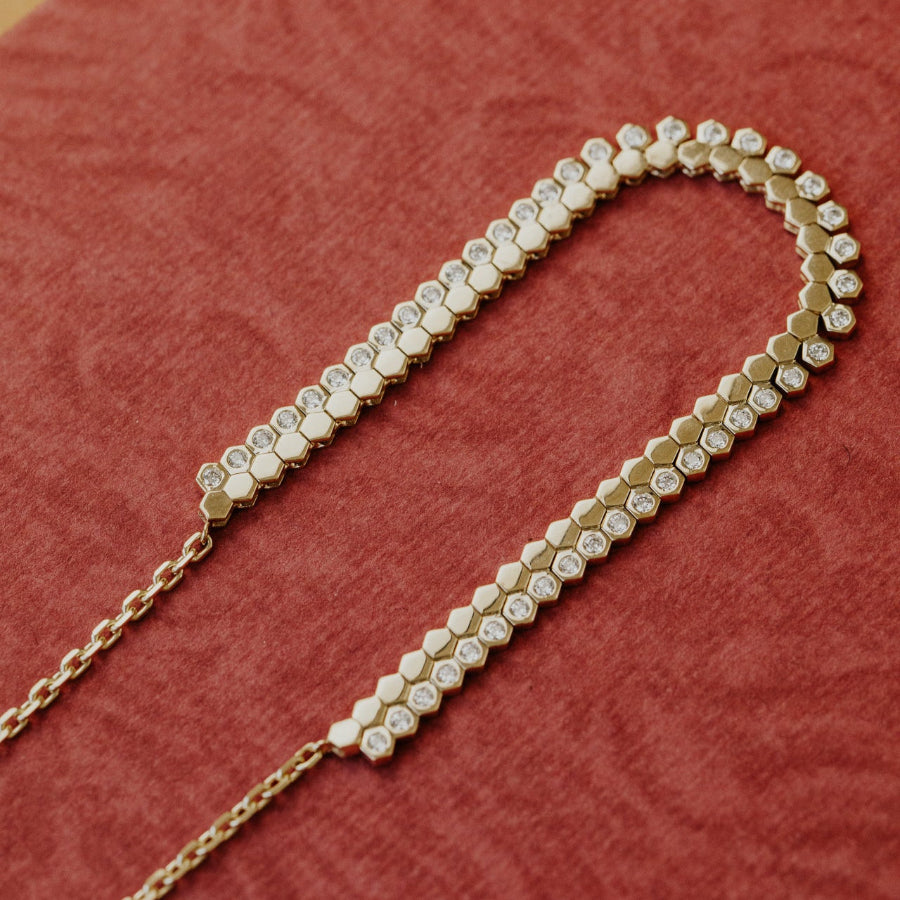 Gold necklace with diamonds on a red fabric background