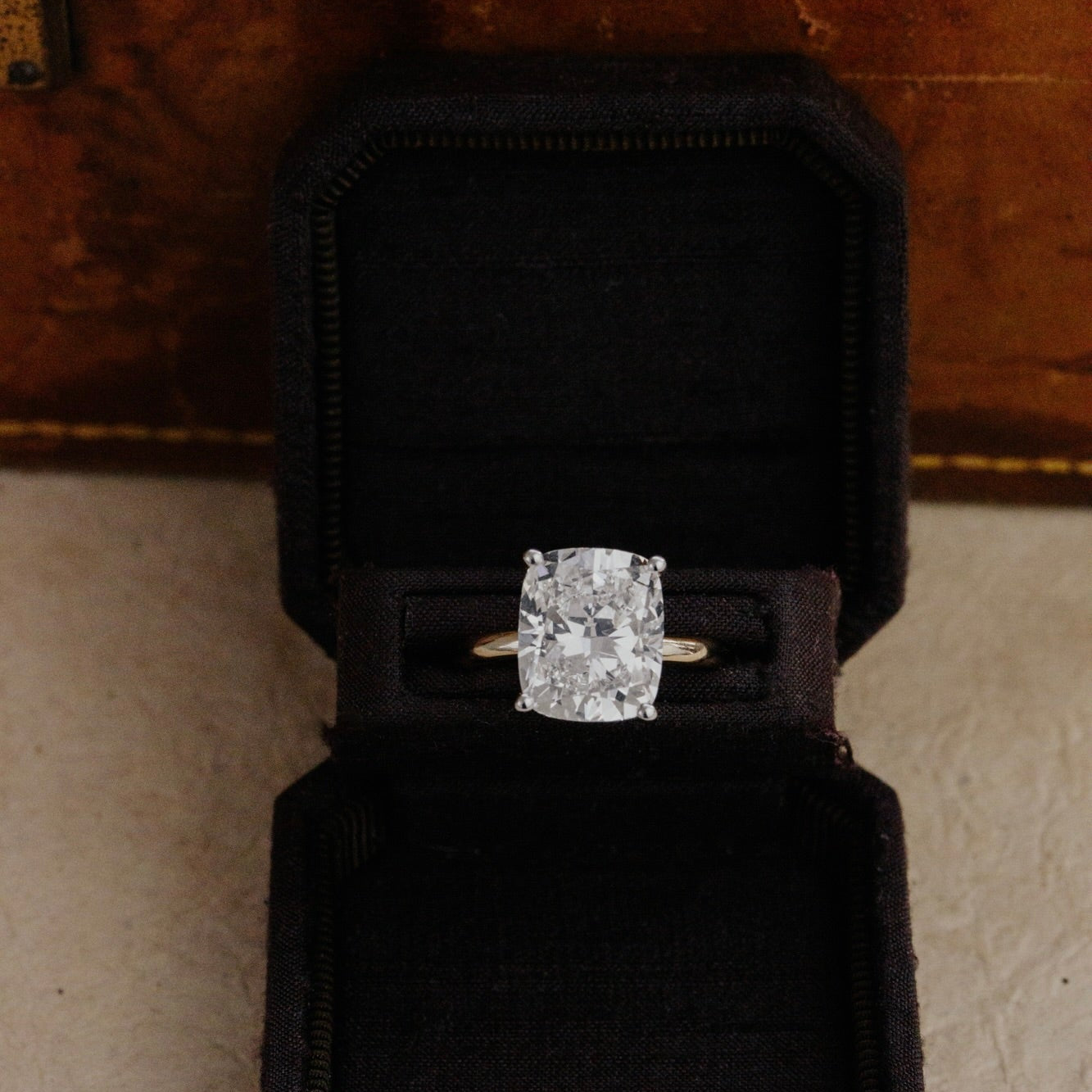 Diamond ring in a black box on a textured surface