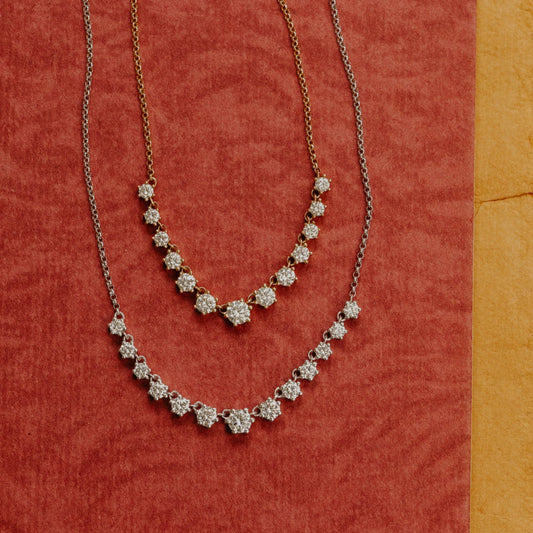 Two diamond necklaces on a red fabric background